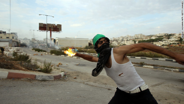 A student from the University of Birzeit throws a molotov cocktail toward Israeli soldiers during clashes.