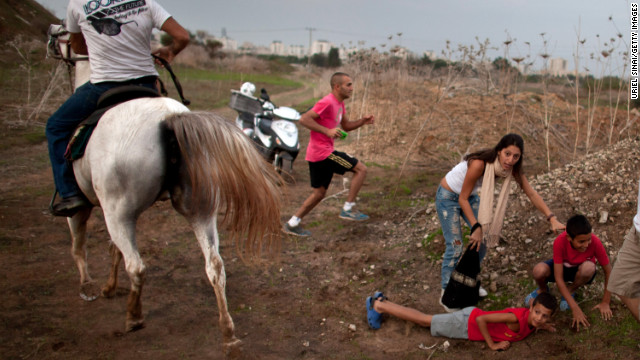 Israeli civilians run for cover during a rocket attack launched from Gaza on November 17 in Tel Aviv, Israel.