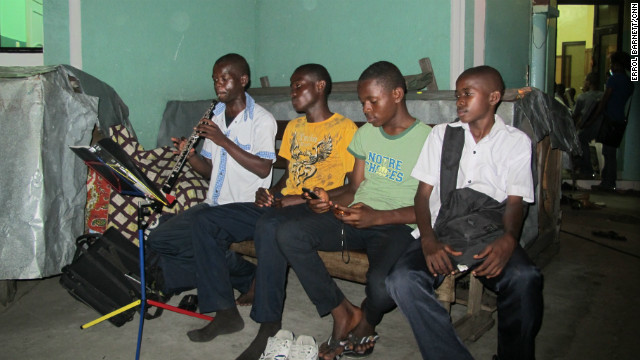 The Kinshasa orchestra does not have enough instruments so these boys must take 20-minute turns while practicing.