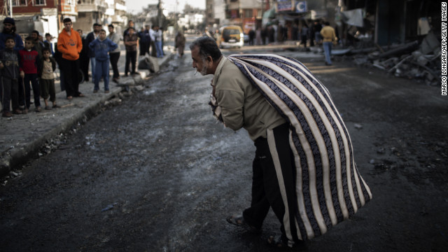 A Palestinian carries a bag of items salvaged from a house destroyed in an Israeli airstrike Tuesday on Gaza City.