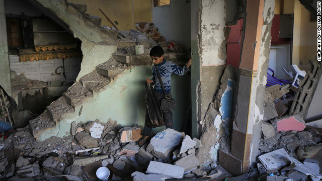 A Palestinian boy walks through the rubble of Hamas commander's house Tuesday in the southern Gaza town of Rafa. An overnight Israeli airstrike targeted the home.