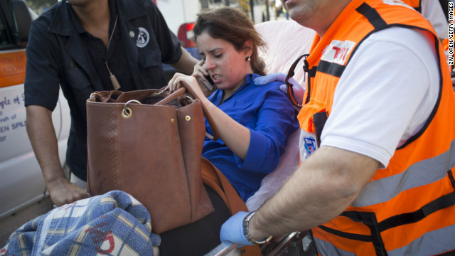 An injured woman is helped from the scene after the explosion.