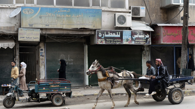 Syrians ride on a horse-drawn cart in the streets of the Tarik al-Bab neighborhood in Aleppo on Sunday, November 18.