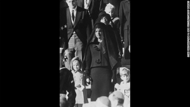 On November 22, 1963, President John F. Kennedy was assassinated while in a presidential motorcade in Dallas. Pictured, Kennedy's widow, Jacqueline Kennedy, children, Caroline and John, and mother, Rose Kennedy, behind, wait outside St. Matthew's Cathedral for the procession to the cemetery during his funeral on November 25. 