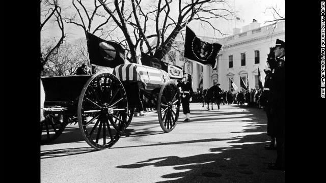 John F. Kennedy's flag-draped casket lies in state in Washington.