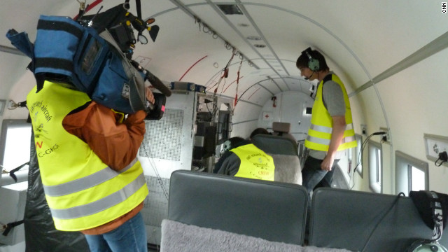 Geophysicist Daniel Steinhage, the head of the mission to Greenland, and his crew outfit the plane with state of the art computers. CNN camera woman Claudia Otto films the scientists. 