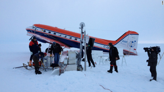 The crew at an ice core drill site after landing safely on the ice. The drilling has to be performed at night because the surface is so slushy from ice melt during daylight that the plane would sink in and get stuck.