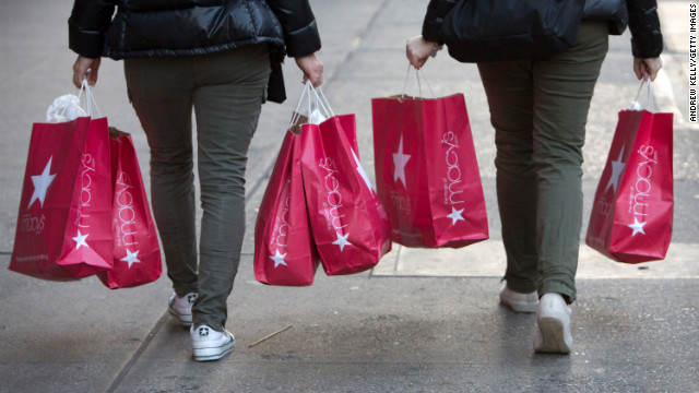 Women carry Macy's bags down 34th Street after shopping the Black Friday sales.