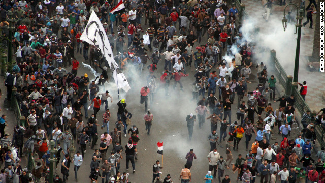 Protesters demonstrating against Morsy run from tear gas fired by Egyptian riot police during clashes in Cairo's Tahrir Square on Friday.