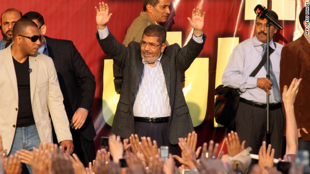 Egyptian President Mohamed Morsy waves to supporters in front of the presidential palace in Cairo on Friday, November 23. Thousands of ecstatic supporters gathered outside the presidential palace to defend their leader against accusations from rival protesters that he has become a dictator. 