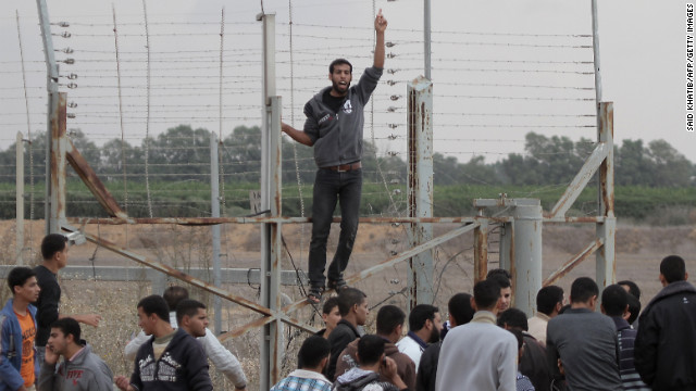 Palestinian youths gesture during a demonstration next to the security fence on the Gaza border with Israel east of Khan Yunis, in the southern Gaza Strip, on Friday, November 23. A Palestinian was shot dead by Israeli forces near the Gaza border, the first casualty since the two sides agreed a truce ending their week-long conflict, Palestinian medical sources said.