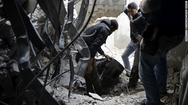 Rescue workers cover a corpse under the debris outside Dar Al-Shifa hospital in Aleppo on Thursday.