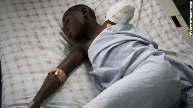 Twelve year old amputee Kakule Elie, hit by a stray bullet, lies in a bed in a hospital in Goma on November 20, 2012.