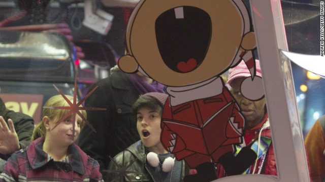 People peer inside the Toys R Us store before the Thanksgiving sale in New York's Times Square.