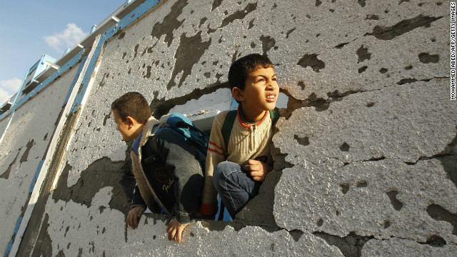 Palestinian schoolboys look through a hole at their damaged school in Gaza City on Saturday.