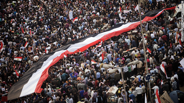 Egyptians carry a giant national flag as tens of thousands take part in a mass rally in Cairo on Tuesday, November 27, against a decree by President Mohamed Morsy granting himself broad powers. 