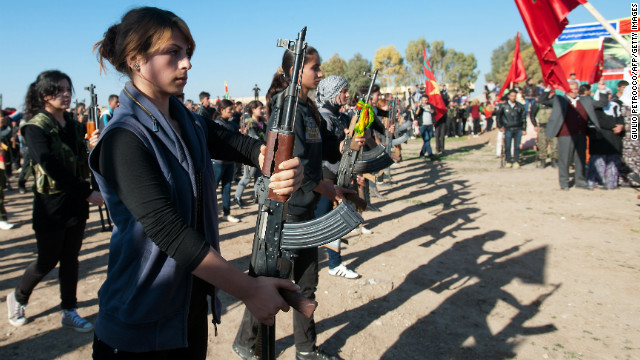 Syrian-Kurdish women and members of the Popular Protection Units, an armed opposition group to the Syrian government, stand guard during a comrade's funeral in a northern Syrian border village on December 1.