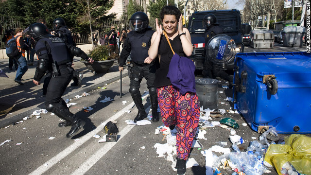 February 29: A protester runs for cover as riot police clash with students during a demonstration in Barcelona, Spain. Tens of thousands of students protested education cuts announced by the Catalan government.