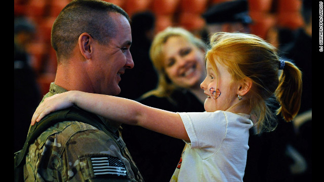 March 28: Sgt. 1st Class Paul Brady of the 182nd Infantry Massachusetts National Guard embraces his 6-year-old daughter, Regan, during a welcome home ceremony in Melrose, Massachusetts. The 182nd Infantry Regiment, one of the original units in the United States military, returned from a yearlong deployment in Afganistan.