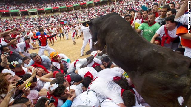 July 8: A wild bull hurdles over people blocking the animal's way into the bullring at the close of the second bull run during the Fiesta de San Fermin in Pamplona, Spain. The festival attracts thousands of people who attempt to outrun the bulls through the narrow streets of the old city.