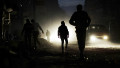 Syrians are silhouetted as they walk in a street in the northern city of Aleppo on November 29, 2012. Internet and telephone services resumed in several provinces, with state news agency SANA saying on December 1, that the outage was due to maintenance work but activists claimed was a deliberate move to deprive the opposition of communications