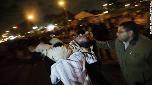 Morsy supporters carry an injured man to safety during clashes with anti-Morsy demonstrators on a road leading to the Egyptian presidential palace on December 5.