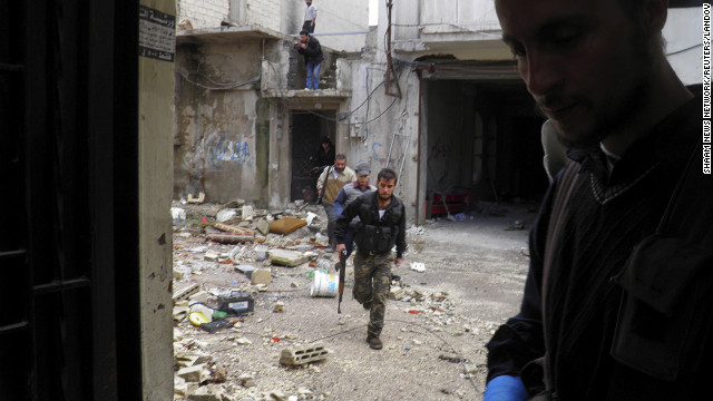 In this handout from the Shaam News Network, Free Syrian Army fighters take cover in destroyed buildings during clashes with forces loyal to Syrian President Bashar al-Assad on December 4.