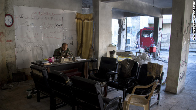 A Syria rebel commander sits behind a desk in his bombed-out position in Aleppo on December 8.