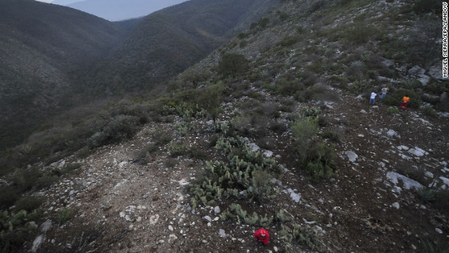 Workers search around the accident scene in Mexico's Sierra Madre Oriental mountain range.