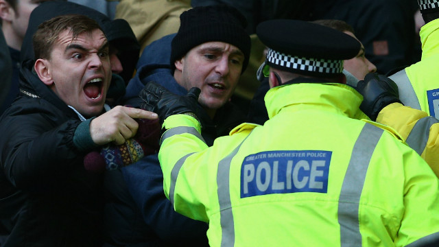 A total of 13 fans were arrested and nine charged -- one with making alleged racist chants. Here a City supporter shouts across the police security cordon.