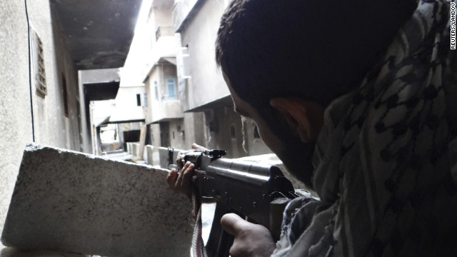 A Free Syrian Army fighter takes position as he aims his weapon in Aleppo's al-Amereya district on Tuesday, December 11.