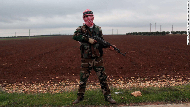 A member of the Syrian opposition's Al-Buraq Brigade stands guard on a main road in the northern Syrian town of Ain Dakna near the Turkish border on Monday, December 10. Click through to view images of the fighting from December, or see photos of the conflict from November.