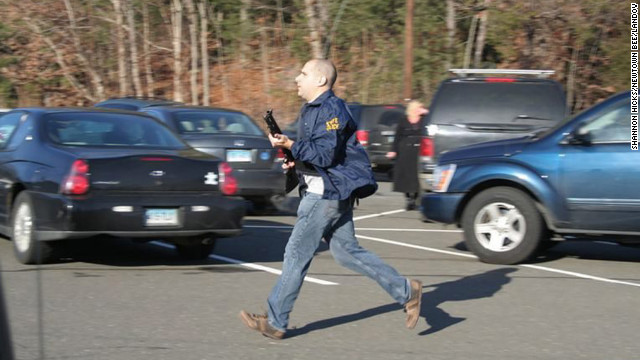 A Connecticut State Police officer runs with a shotgun at the Sandy Hook Elementary School in Newtown on December 14.