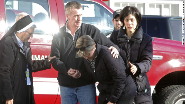 People try to deal with the shock of the attack outside Sandy Hook Elementary School on December 14.