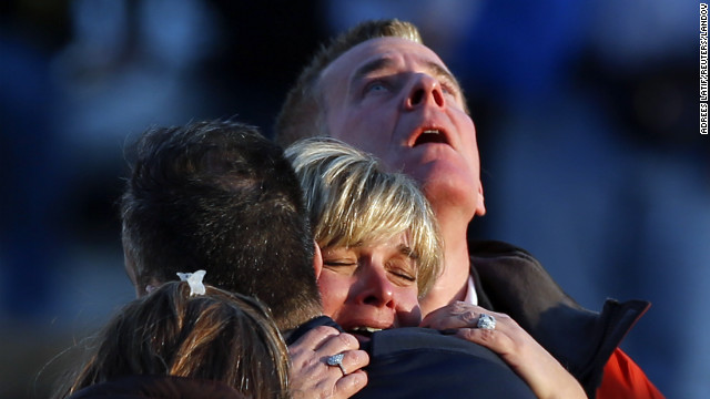 People weep and embrace near Sandy Hook Elementary School on Friday, December 14.