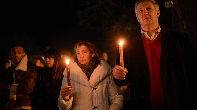 People gather for a prayer vigil at St Rose Church in Newtown on December 14.