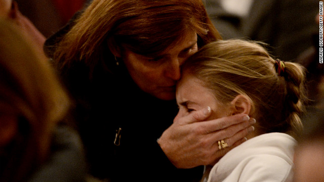 Women comfort each other during the vigil at St. Rose Church.