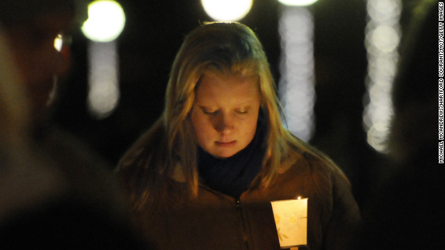 Corinne McLaughlin, a student at the University of Hartford, bows her head during a candlelight vigil at Hartford, Connecticut's Bushnell Park on Friday, December 14, honoring the students and teachers who died at Sandy Hook Elementary School in nearby Newtown earlier in the day.