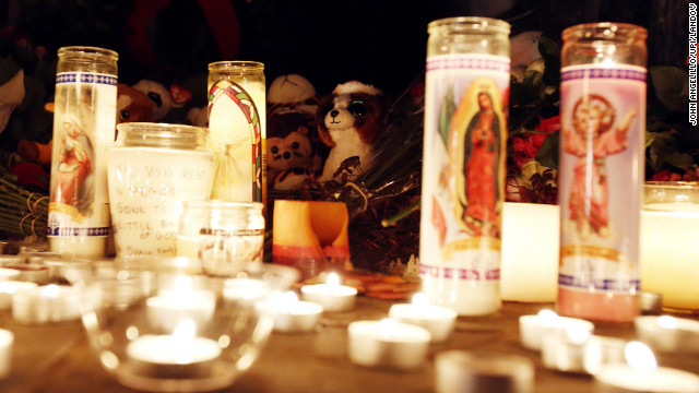 Candles light up a memorial outside of Saint Rose of Lima Church in Newtown.