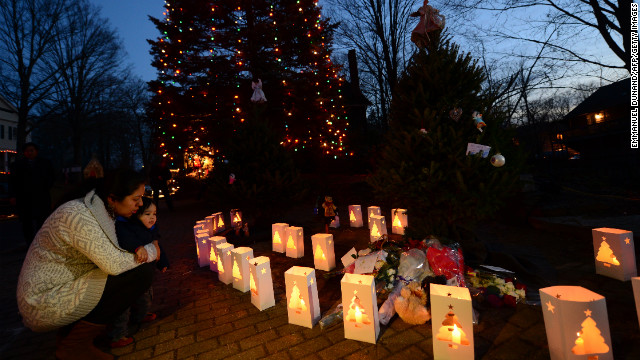 Candles burn next to a lighted tree at a makeshift shrine in Newtown.