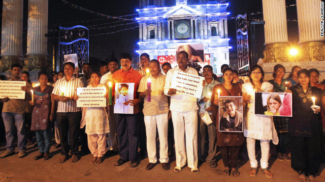 People in Bangalore, India, hold cards and photographs of the slain at a candlelight vigil outside a Catholic church on December 16.