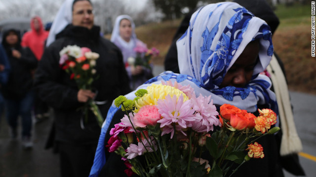 Members of Sisters of Christian Charity go to lay flowers in front of the Sandy Hook Elementary School on December 16 in Newtown.