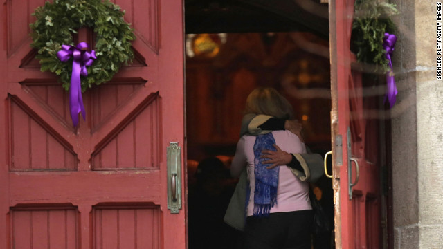 A woman receives a hug as she leaves morning service December 16 at Trinity Church in Newtown near the elementary school.