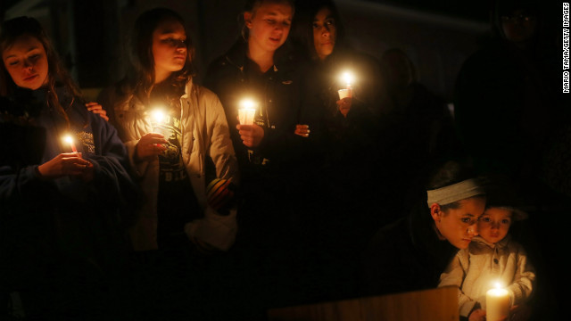 From left: Newtown residents Claire Swanson, Kate Suba, Jaden Albrecht, Simran Chand and New London, Connecticut, residents Rachel Pullen and her son, Landon DeCecco, hold candles at a memorial for victims on Sunday, December 16, in Newtown, Connecticut. 