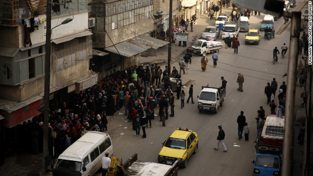 Syrians line up outside a bakery offering cheap bread in Aleppo, Syria on Sunday, December 16. Click through to view images of the fighting from December, or <a href='http://www.cnn.com/2012/12/04/middleeast/gallery/syria-unrest-november/index.html' target='_blank'>see photos of the conflict from November</a>.