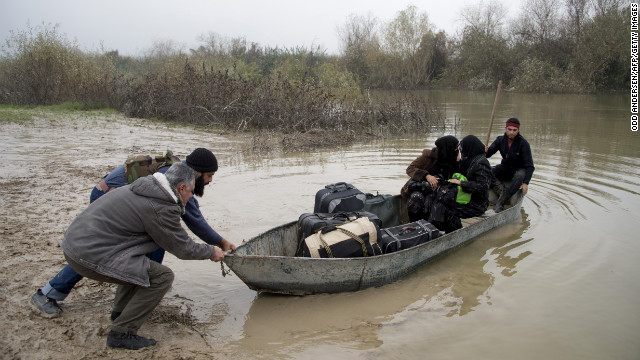 Rebel fighters push out a boat carrying two Syrian women fleeing to Turkey through the Orontes River near the northern Syrian town of Darkush on December 14.