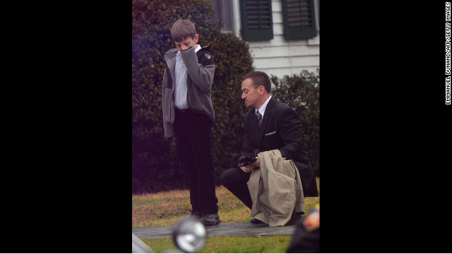 A man comforts a young mourner at Honan Funeral Home while attending the funeral for Jack Pinto, 6, on December 17.