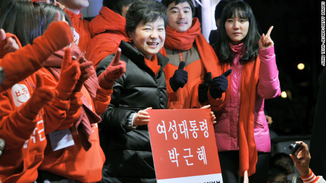 South Korea's presidential candidate Park Geun-hye of the ruling New Frontier Party holds a placard reading 'Woman President Park Geun-hye' during her election campaign in Seoul on December 18, 2012. If she wins, she will be the first woman leader of the country.