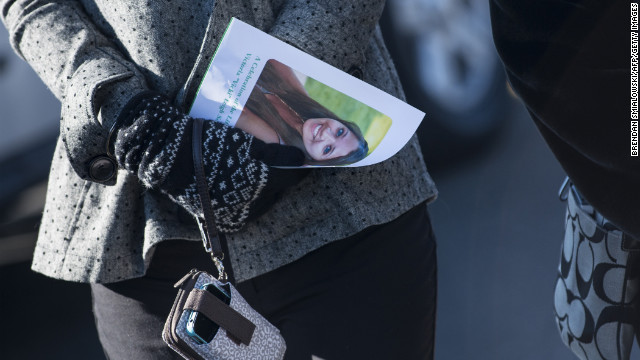 A woman carries a program with Soto's photo after attending a funeral for the slain teacher in Stratford on December 19.