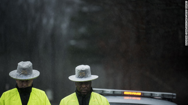 Connecticut State Police block the road to Sandy Hook Elementary School during a moment of silence on December 21. A week ago, a gunman forced his way into the school and shot and killed 26 people, including 20 children.